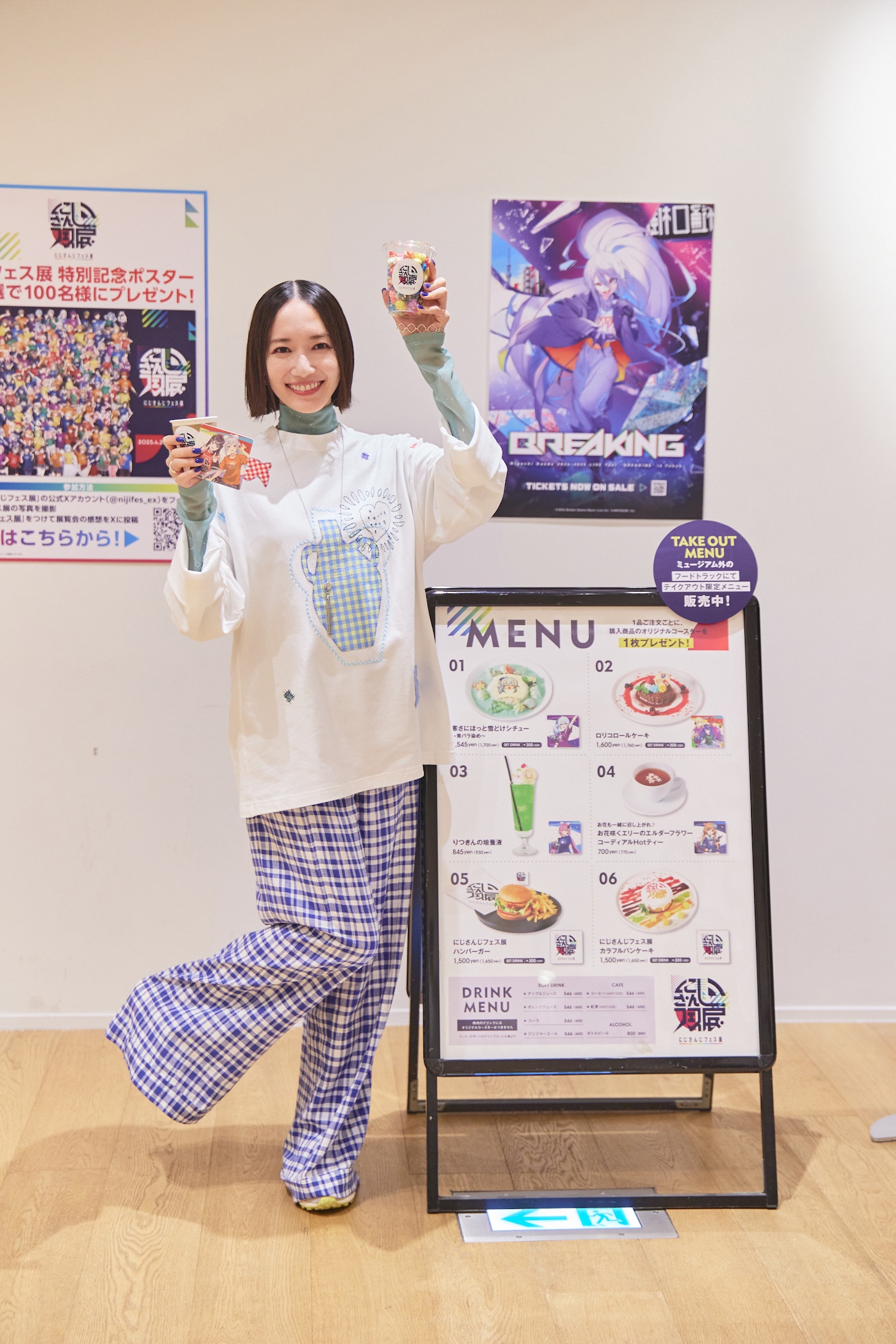 右手に「楓と美兎 ～ジンジンじょぼじょぼ編～」、左手に「いでぃおすーぱーレインボーップコーン」を持ってポーズ。