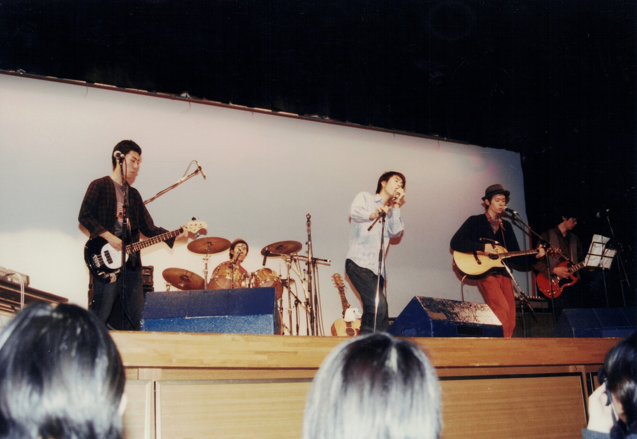 プランクトンの文化祭ライブの様子。中央のボーカルが佐藤良成。