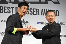 トロフィーを授与される尾形貴弘（パンサー）。