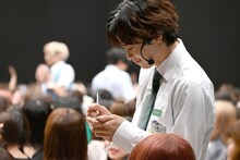 8号車の話をメモするタクヤ。