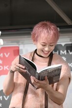 超特急メンバーからのコメントに笑顔で目を通すシューヤ（超特急）。