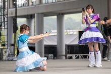 銃を構える中山莉子（左）を撮影する真山りか（右）。