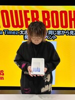 「同じ窓から見た違う月」を手にする太志。