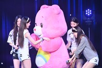 メンバーがケアベアを歓迎する中、こっそりしっぽに触れるMOKA（右端）。