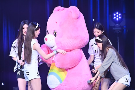 メンバーがケアベアを歓迎する中、こっそりしっぽに触れるMOKA（右端）。