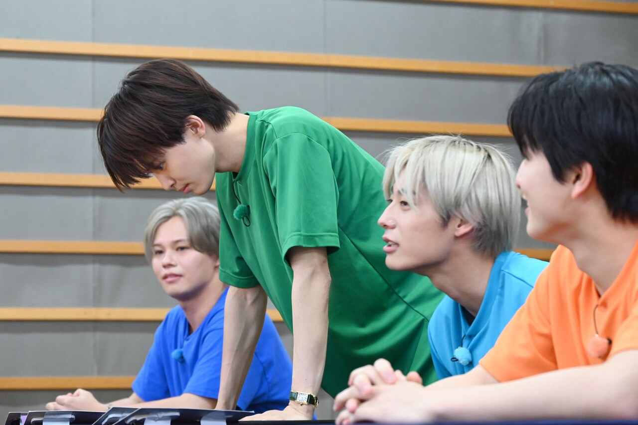 鋭い眼光でバラエティ班の名前の札を見つめるタクヤ（左から2番目