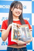 カフェの入口で撮影した写真を見せる後藤花（アンジュルム）。