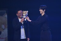 古家正亨（左）の肩に柴犬を乗せるユンホ（右）。