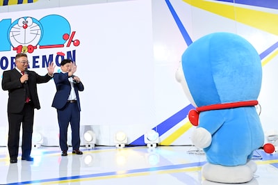 ドラえもんを歓迎するサンドウィッチマン（左）。