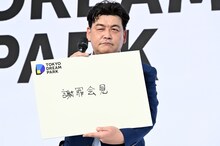 「謝罪会見」と記したフリップを見せる富澤たけし（サンドウィッチマン）。