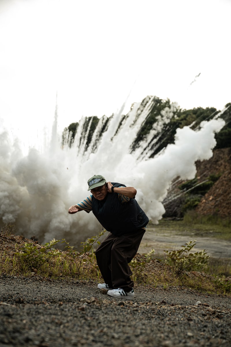 スチャダラパー「ビート道 feat. ロボ宙」ミュージックビデオ撮影の様子。爆破を背にしたSHINCO。