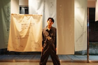 映画館スタッフによって作られた装飾に囲まれる折坂。