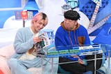 「観光列車大図鑑」を読む佐久間大介(Snow Man)と日村勇紀(バナナマン)。©日本テレビ