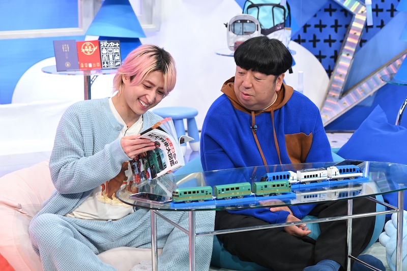 「観光列車大図鑑」を読む佐久間大介(Snow Man)と日村勇紀(バナナマン)。©日本テレビ