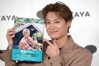 本を指差す髙松アロハ（超特急）。