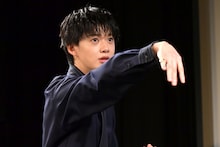 趣味のダーツを壇上で再現する小川史記（BUDDiiS）。