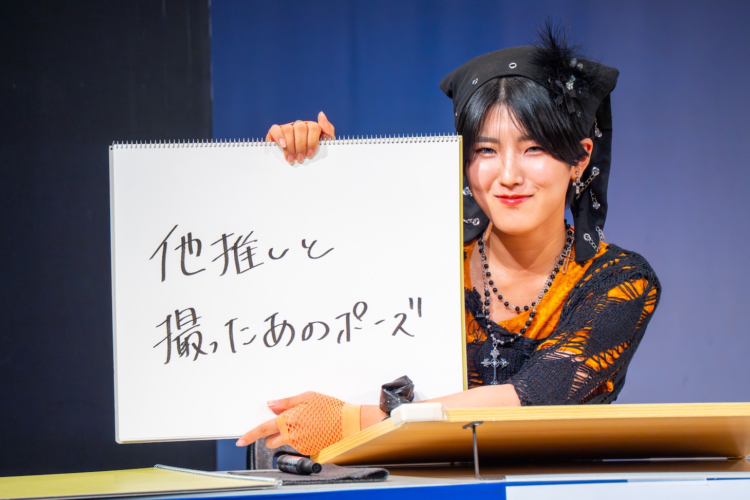 「会場の皆さんと記念撮影。アイドル『では、皆さん〇〇のポーズでお願いします』」というお題に答える小島はな（AMEFURASSHI）。