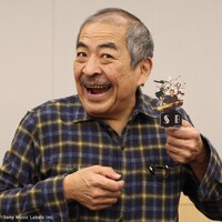 アクリルフィギュアを手にする吾妻光良。