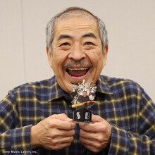 アクリルフィギュアを手にする吾妻光良。