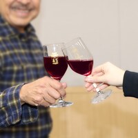 ワイングラスで乾杯する吾妻光良。