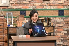 「Wormhole / Yumi AraI」のジャケットを手にする松任谷由実。 ©テレビ朝日