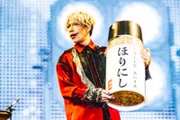 巨大な「ほりにし」のスパイスボトルを手にした歌広場淳（B / ゴールデンボンバー）。（撮影：青木カズロー）