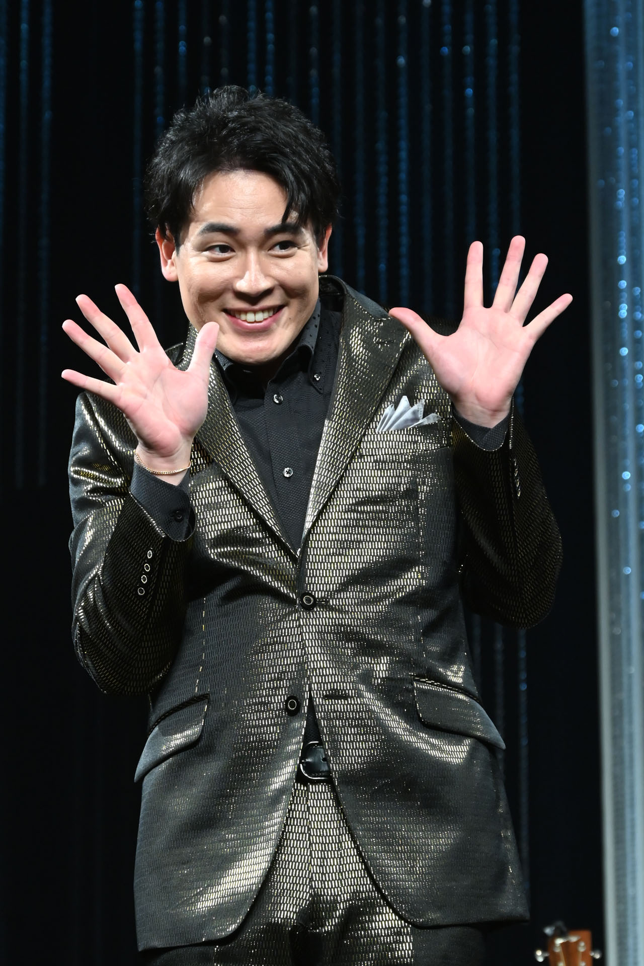 囲み取材でいろんなポーズを繰り出す木村徹二。