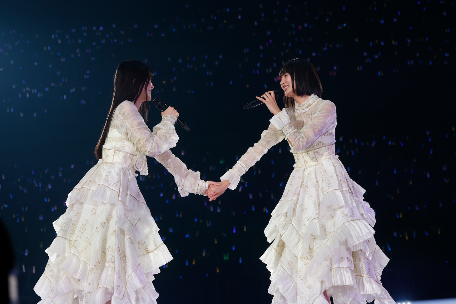 手をつなぐ久保史緒里と遠藤さくら。（撮影：鈴木健太［KENTA Inc.］）