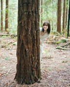松田里奈（櫻坂46）1st写真集「まつりの時間」より、木陰から顔を出す松田里奈。（撮影：北浦敦子）