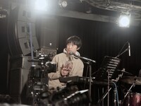 「TEAM」のジャケットを客席に見せる蓮沼執太。（撮影：永田崚）