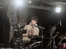 「TEAM」のジャケットを客席に見せる蓮沼執太。（撮影：永田崚）