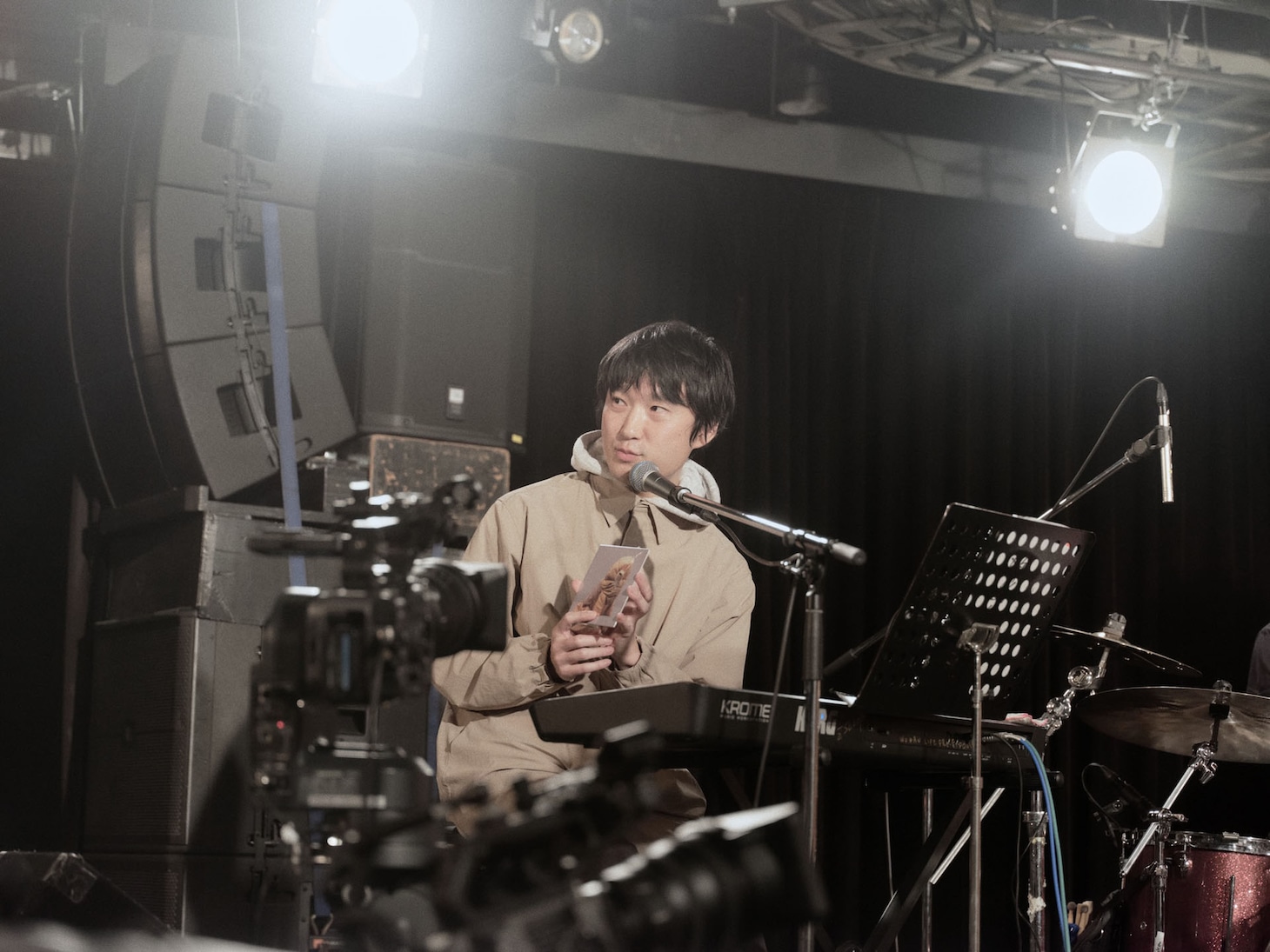 「TEAM」のジャケットを客席に見せる蓮沼執太。（撮影：永田崚）