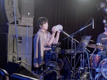 ペットボトルを振って水の音を出す蓮沼執太。（撮影：永田崚）