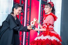 のんからトロフィーを受け取る坂井仁香（超ときめき♡宣伝部）。