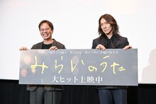 パネルが斜めになっていることを指摘されてカメラマンを睨みつける吉井和哉（右）。