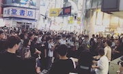 渋谷で大勢のオーディエンスを前にストリートライブを行うOmoinotake。
