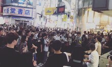 渋谷で大勢のオーディエンスを前にストリートライブを行うOmoinotake。