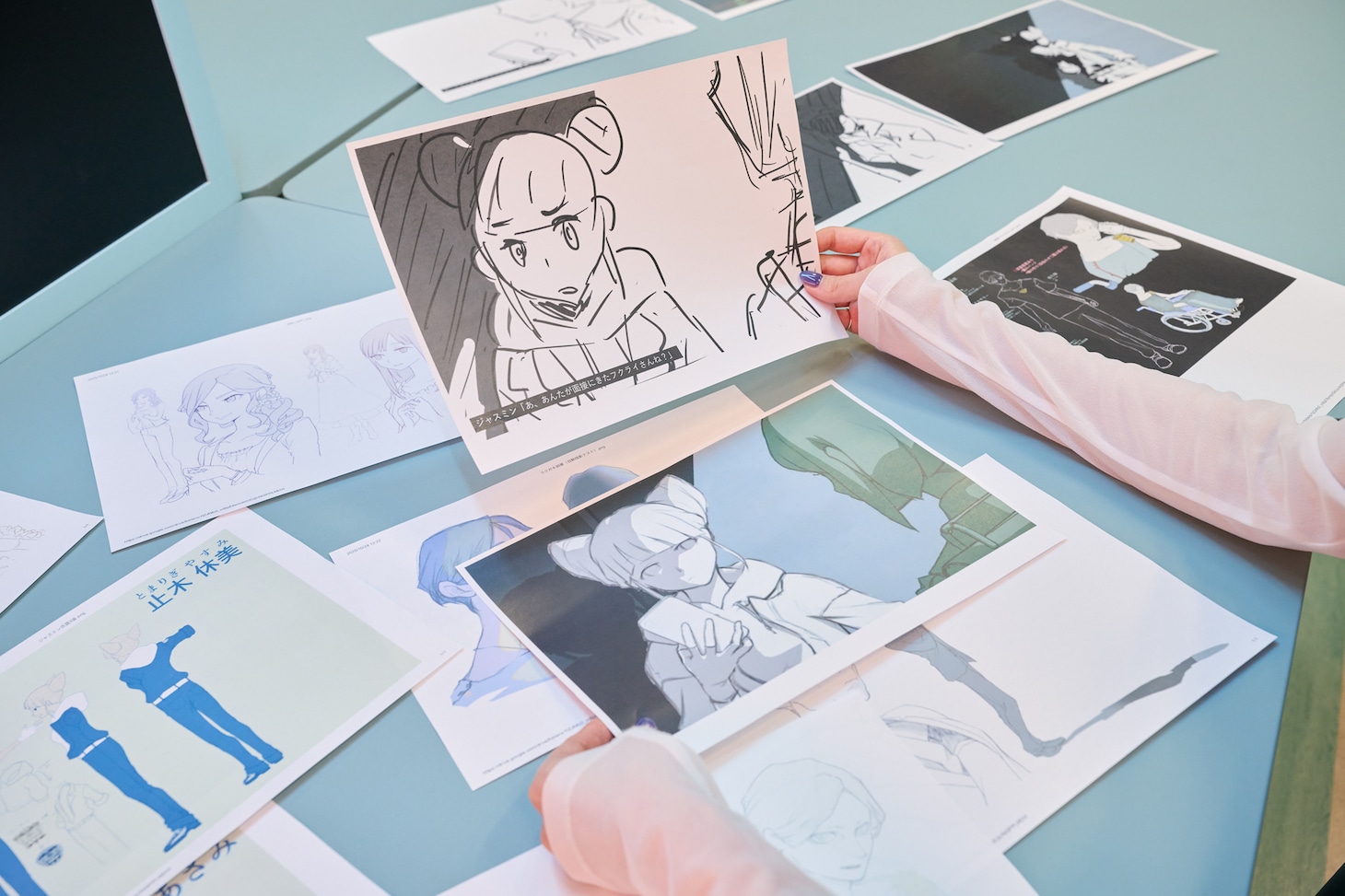 のっちさんが手にしているのはオープニングムービーの絵コンテ。右手に持っているのがハフハフ・おでーんさんが描いたラフ、左手に持っているのがきっきゃわーさんが描いた清書です。