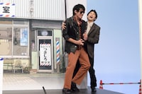 大暴れする日暮歩（中島歩）を抱えながらステージを降りる月白司（草川拓弥）。