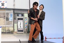 大暴れする日暮歩（中島歩）を抱えながらステージを降りる月白司（草川拓弥）。