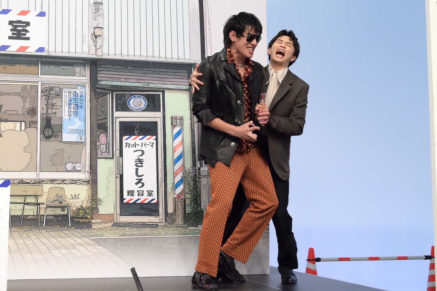 大暴れする日暮歩（中島歩）を抱えながらステージを降りる月白司（草川拓弥）。