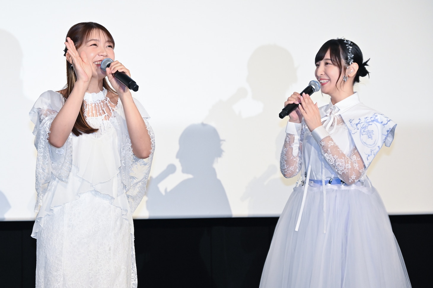 アメリカから帰国し、観客に手を振る三森すずこ（左）と温かく迎える佐倉綾音（右）