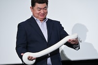 爬虫類のプロが白蛇を手にステージに登場。