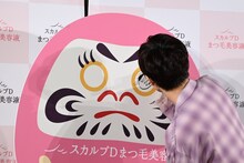 だるまの目を丁寧に塗り潰す草川拓弥（超特急）。