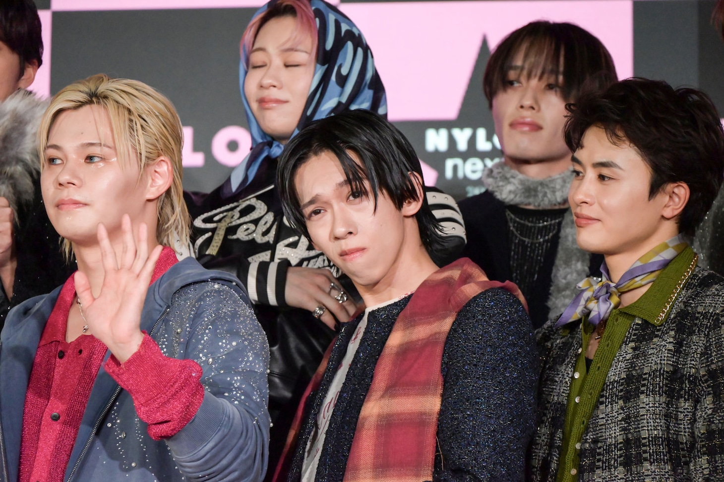 誇張した決めポーズを取るリョウガ（下段中央）を見つめるタクヤ（下段右）。