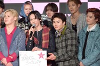 真顔でリョウガのフリップを紹介するタクヤ（下段中央右 / 超特急）。