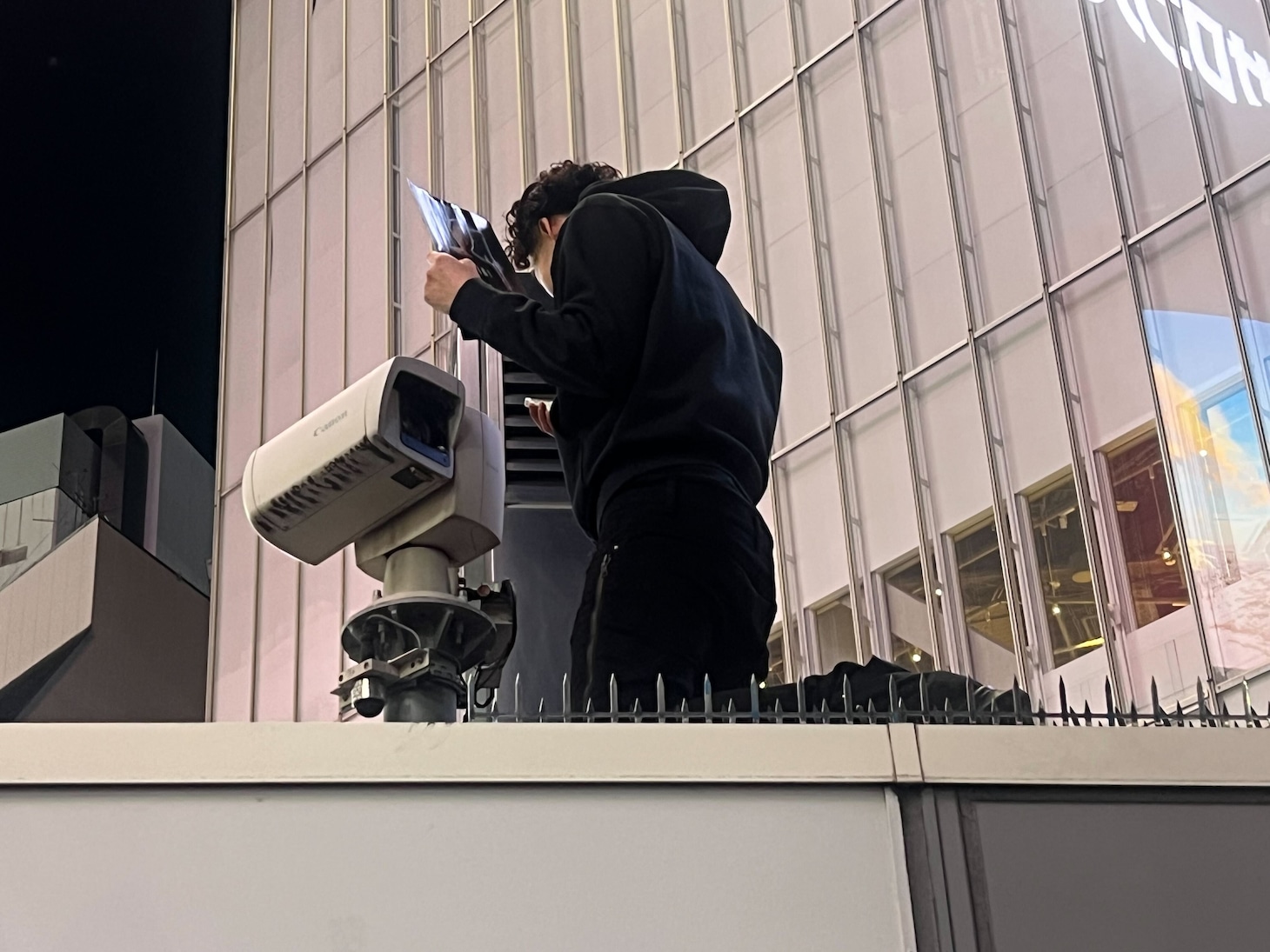 ライブカメラに映り込んでアルバムを宣伝するTee Shyne。