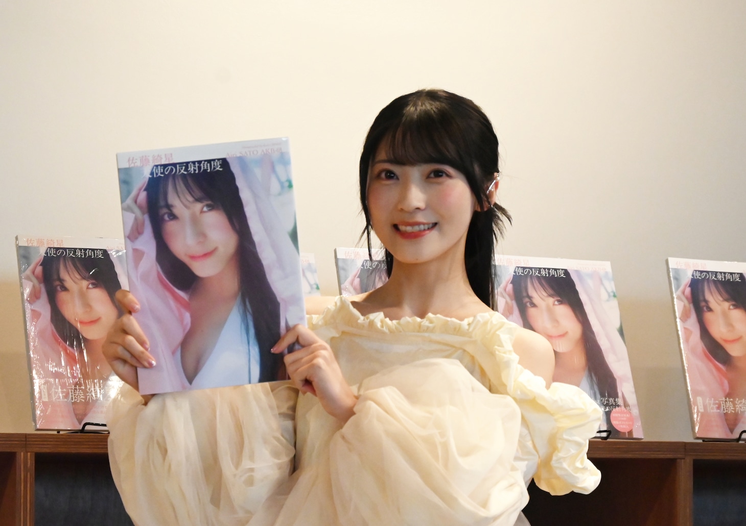 1st写真集「天使の反射角度」を手に持つ佐藤綺星。