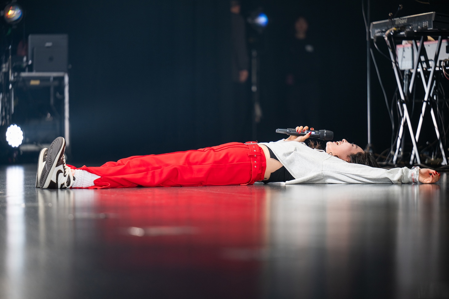 ステージに寝そべる柏木ひなた。