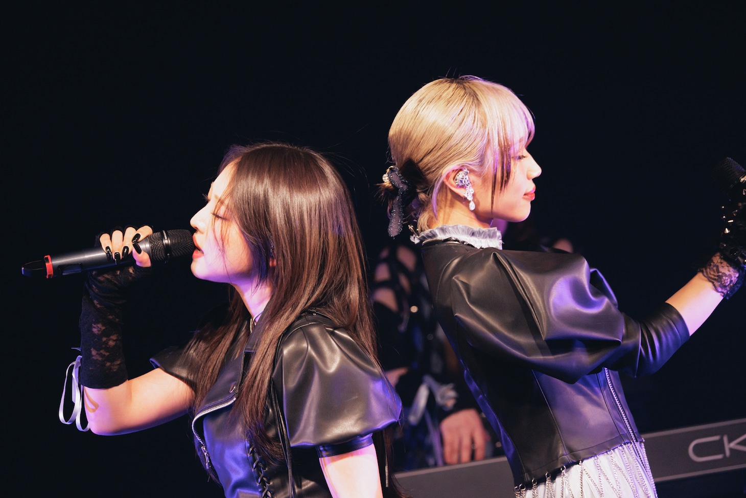 背中を合わせて歌唱するCiONの愛佳（Vo）と栞音（Vo）。（撮影：ヨシモリユウナ）